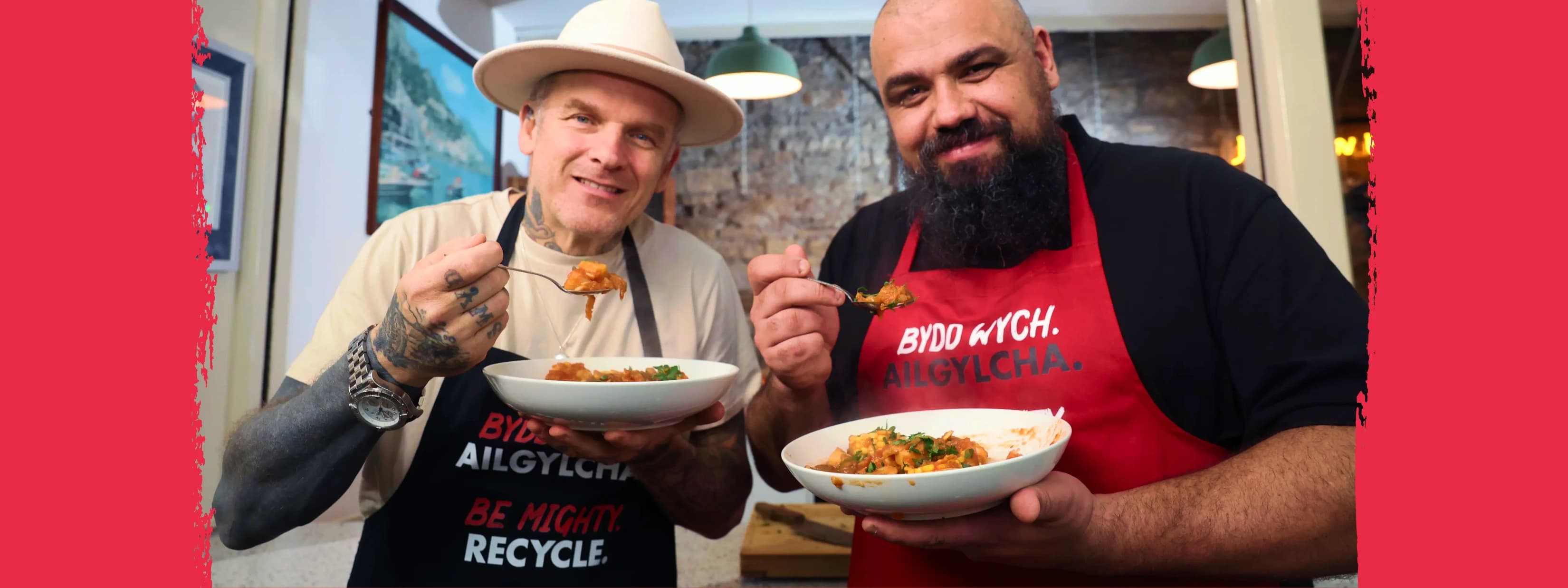 Matt Pritchard and Chris Roberts standing in Cardiff Market holding white bowls of food and forks.